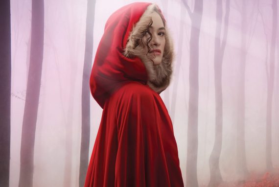 Young woman in a red cape as Little red riding hood in the musical Into the Woods. Presented by Opera Queensland in Brisbane and Queensland Theatre. Playing at QPAC Glasshouse Theatre in 2026